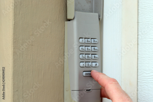 Fényképezés finger pushing buttons to enter secret code on keypad - garage door opener - hom