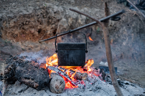 Cooking in a pot on the fire when hiking to mountain.