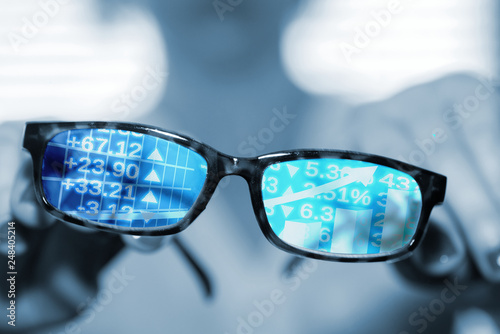 Eine Frau, eine Brille und Aktienkurse an der Börse