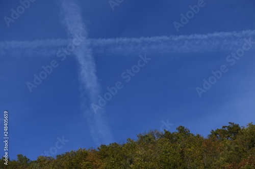 Hills with trailsof planes in the sky photo