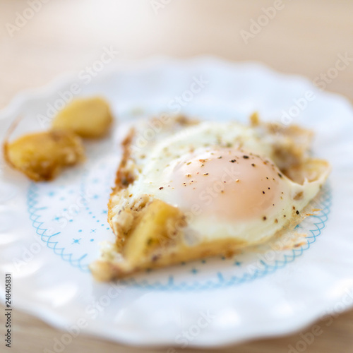 Scrambled eggs. Fried eggs with potato cubes on the plate