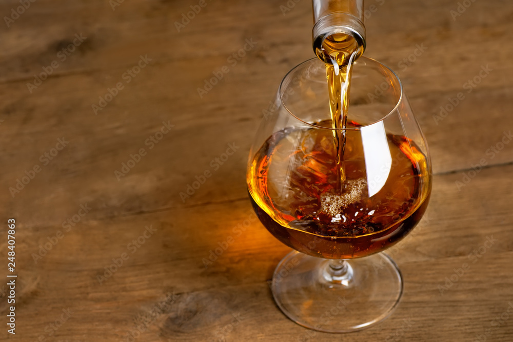 brandy or cognac pouring into glass brandy or cognac pouring into glass