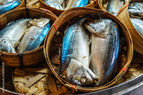 Close up The famouse Thai traditional Steamed mackerel fish in basket bamboo or wicker basket in thailand market. photo