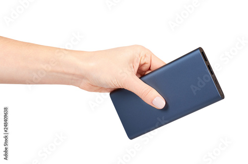Hand with dark blue power bank for charging mobile devices, external battery.