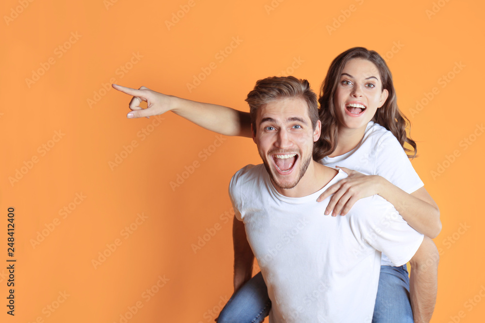 Lovely couple smiling together and pointing away over yellow background. Lovely couple smiling together and pointing away over yellow background.