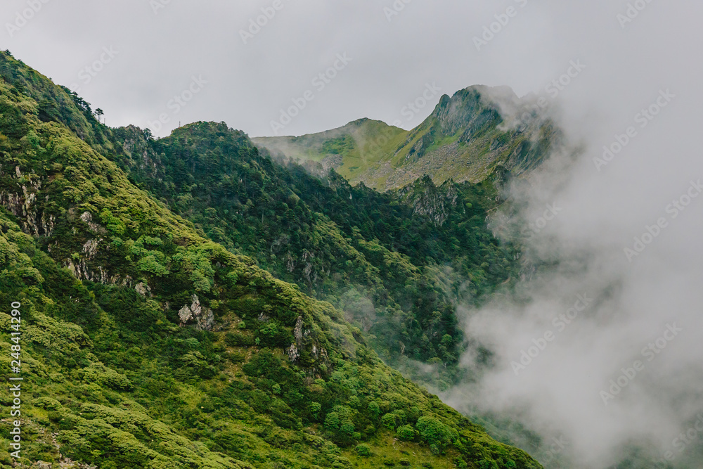 Mountain ridges covered by clouds and fog on top of Cangshan Mountains in Dali, Yunnan, China Mountain ridges covered by clouds and fog on top of Cangshan Mountains in Dali, Yunnan, China