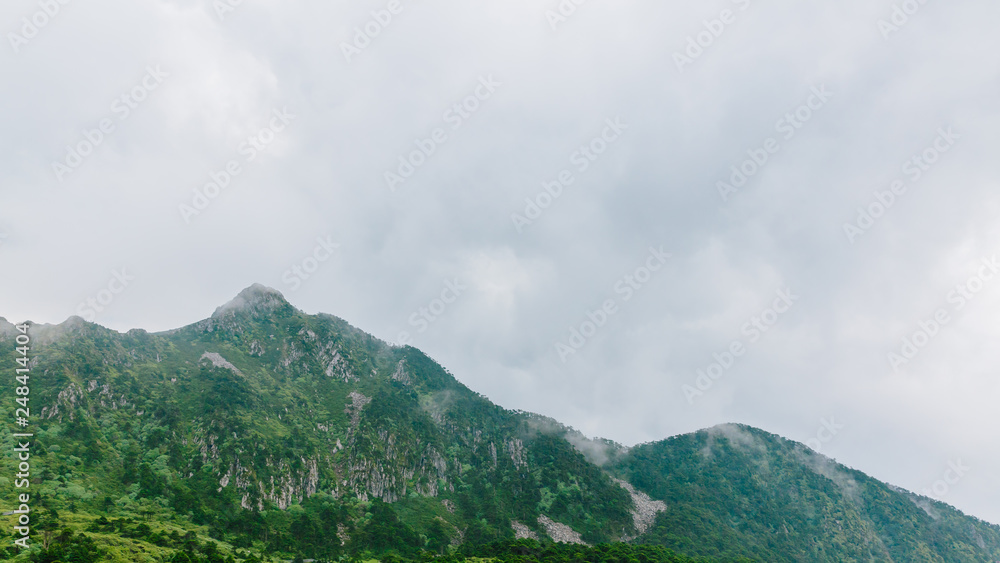 Mountain ridges under clouds and fog on top of Cangshan Mountains in Dali, Yunnan, China