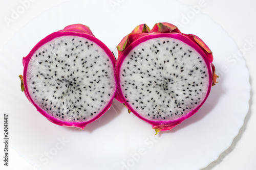dragon fruit cut in half lying on a white plate