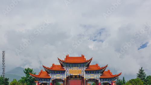 Traditional Chinese architecture in Chongsheng Temple against Cangshan Mountains covered in clouds in Dali, Yunnan, China
