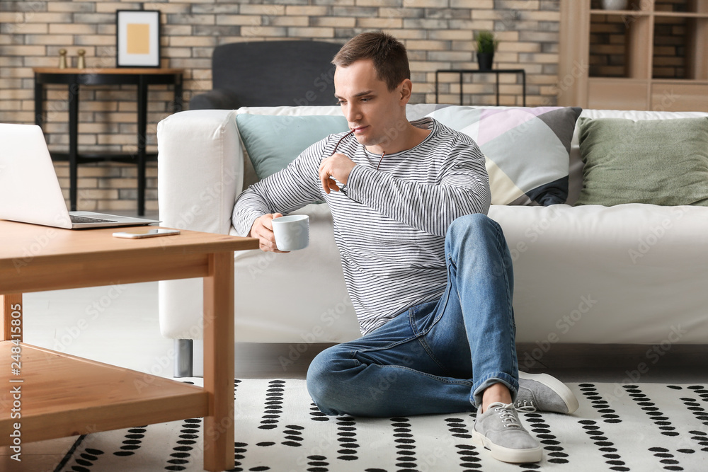 Fototapeta premium Handsome young man drinking coffee at home