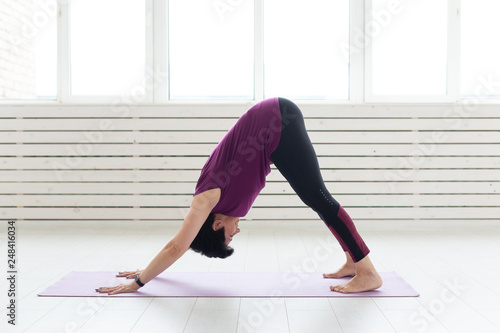 Healthy lifestyle, people and sport concept - Middle aged woman doing yoga