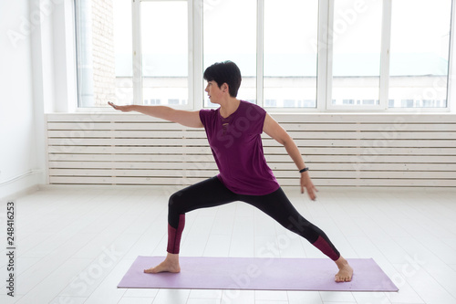 Healthy lifestyle, people and sport concept - Middle aged woman doing yoga