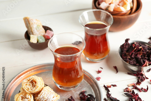 Turkish tea in traditional glasses with East sweets on white table