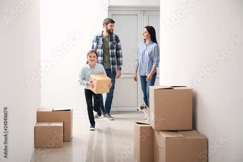 Family with cardboard boxes moving into new house © Pixel-Shot