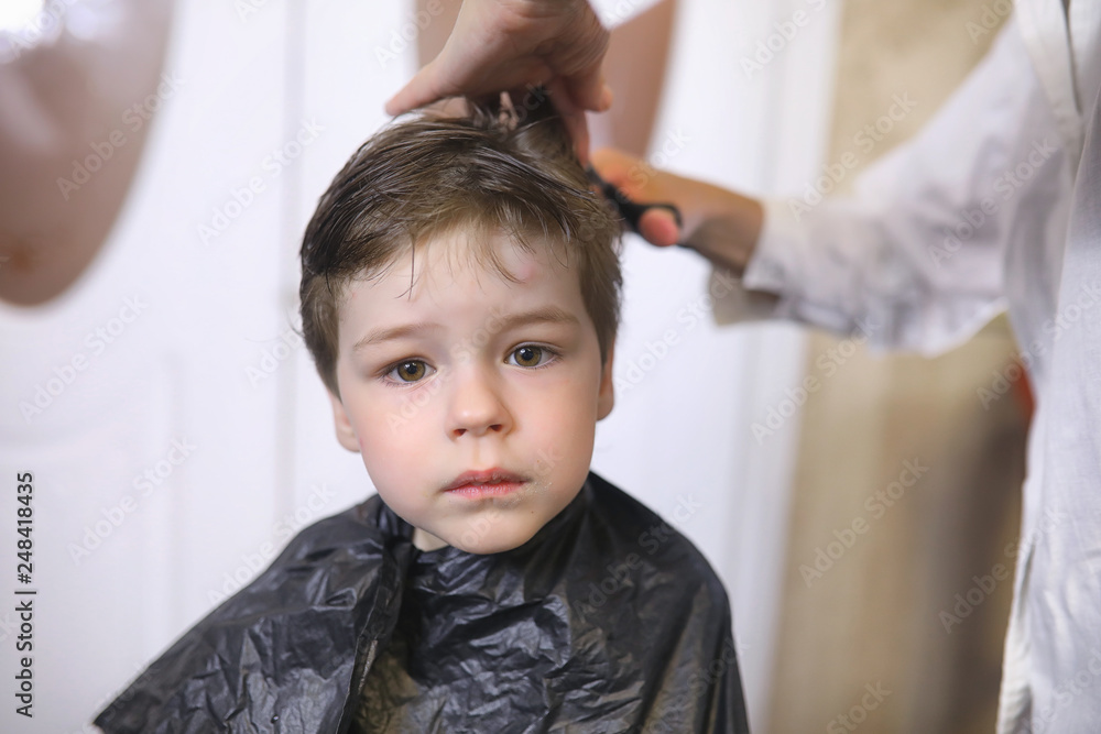 Hairdresser and boy. The boy is doing his hair. Cut hair child in the hairdresser. Hairdresser and boy. The boy is doing his hair. Cut hair child in the hairdresser.