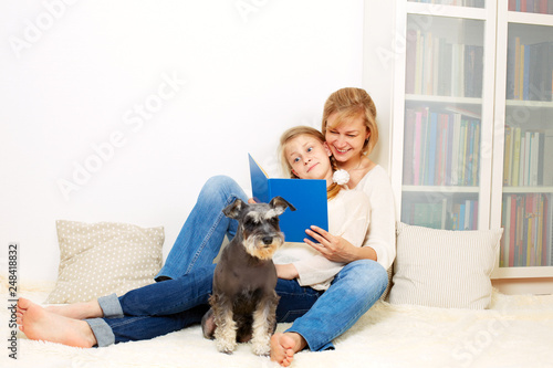 Mother with her 10 years old kid girl reading the book, casual lifestyle photo series. Cozy homely scene. © natasnow