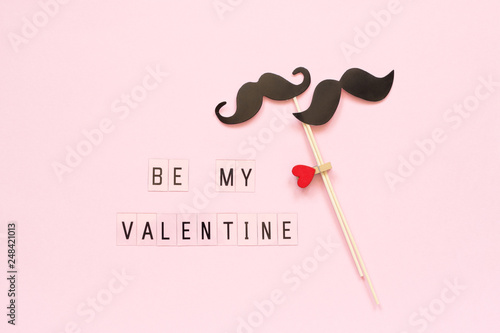 Couple paper mustache props on stick fastened clothespin heart and text Be my Valentine on pink background Concept Homosexuality gay love. Valentine's Day, Valentine card Creative Top view