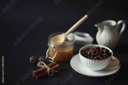 Set for breakfast. Sweets and pastries with nuts for tea on a black background. A coffee cup and patties.