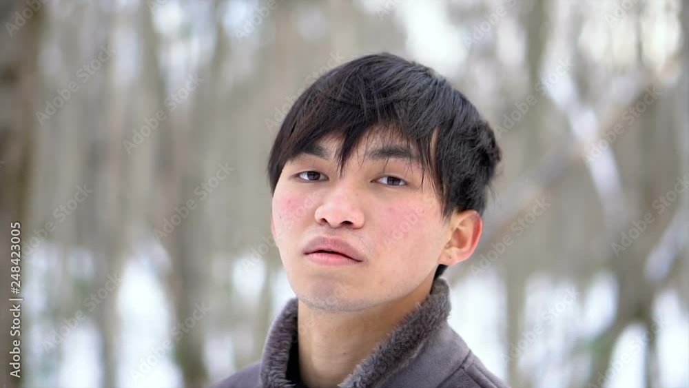 Young Mixed Ethnicity Asian Man in Snow Covered Winter Forest Close Up Young Mixed Ethnicity Asian Man in Snow Covered Winter Forest Close Up