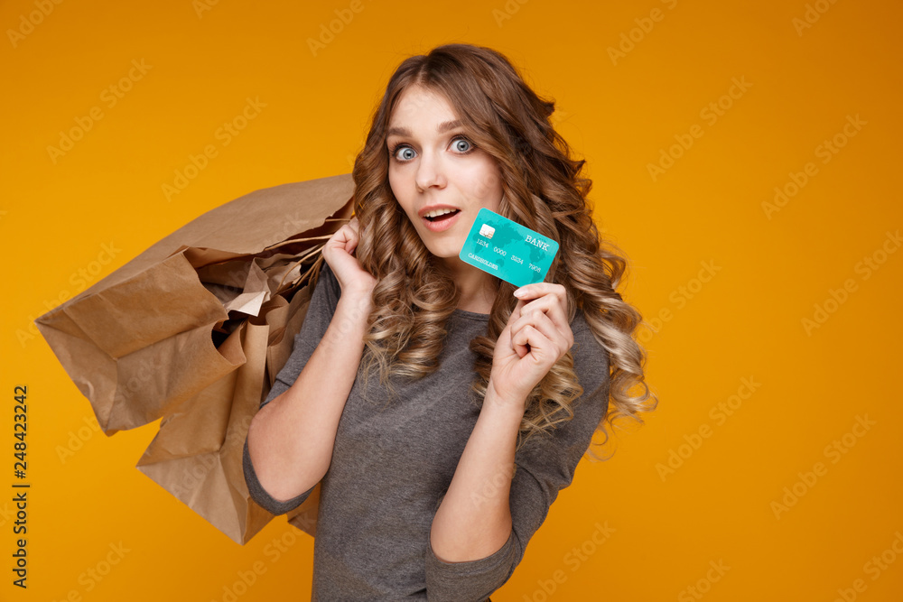 Young beautiful woman holding shopping bags and a blue credit card Young beautiful woman holding shopping bags and a blue credit card