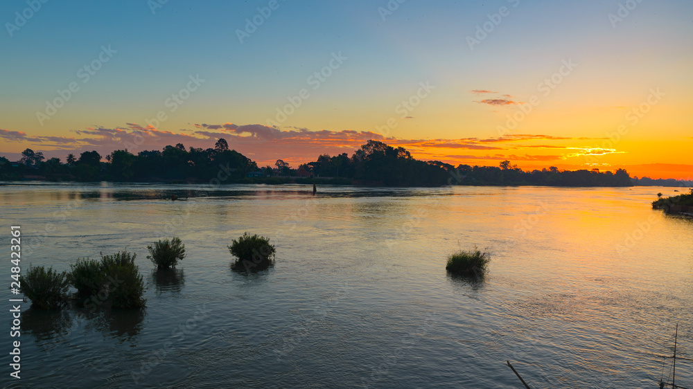 Mekong River 4000 islands Laos, sunrise dramatic sky, mist fog on water, famous travel destination backpacker in South East Asia