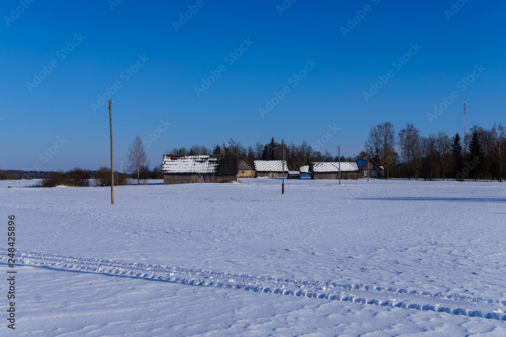 Old houses in winter, frosty morning in Latvia in the village.