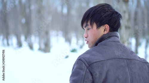 Young Asian Mixed Ethnicity Man Standing in Winter Forest photo