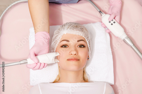 woman receiving wrinkle treatment at beauty salon. Acoustic Wave Therapy for skin rejuvenation photo
