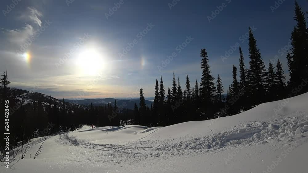 the guy on a bright snowmobile in the winter forest. riding up the hill in the forest with jumps and turns. boondocking, blue sky. snowmobile with splashes of snow and whirlwinds. front view. Slowmo the guy on a bright snowmobile in the winter forest. riding up the hill in the forest with jumps and turns. boondocking, blue sky. snowmobile with splashes of snow and whirlwinds. front view. Slowmo