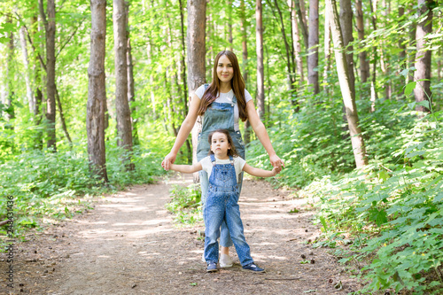 Nature, fun and family concept - Mother and child walking in forest and playing