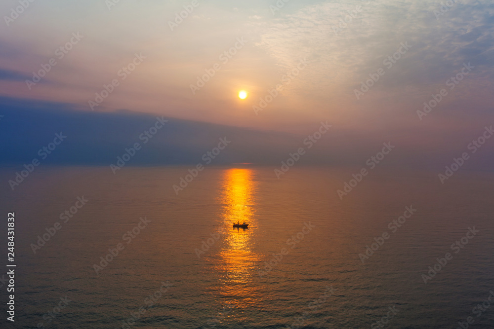 Fototapeta premium Lonely boat in the sea at sunset time