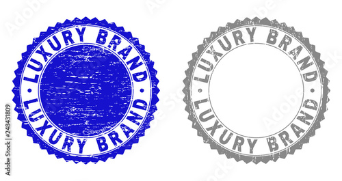 Grunge LUXURY BRAND stamp seals isolated on a white background. Rosette seals with grunge texture in blue and grey colors. Vector rubber stamp imprint of LUXURY BRAND label inside round rosette.