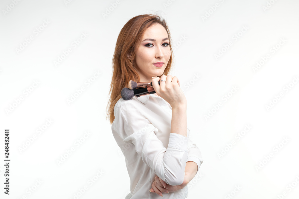 Makeup artist, beauty and cosmetics concept - Korean female make-up artist with makeup brushes on white background Makeup artist, beauty and cosmetics concept - Korean female make-up artist with makeup brushes on white background