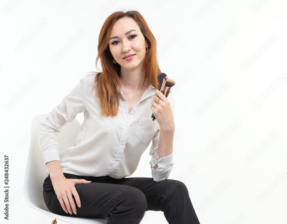 Attractive visagist or korean make-up artist holding a makeup brushes on white background Attractive visagist or korean make-up artist holding a makeup brushes on white background