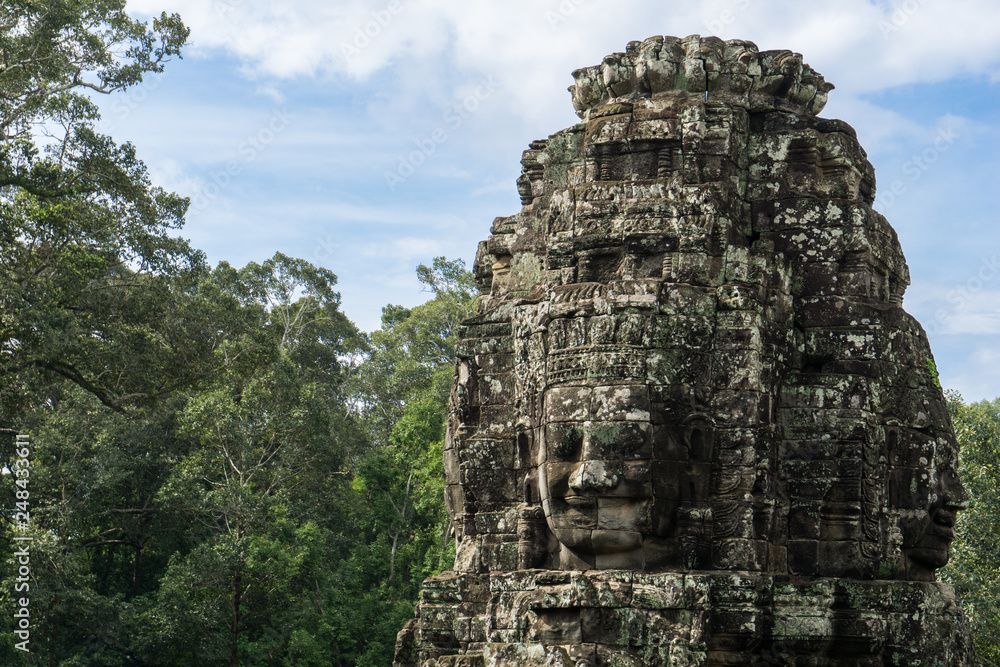 Beautiful stone sculpture at the Angkor Wat temple complex with jungle in the background