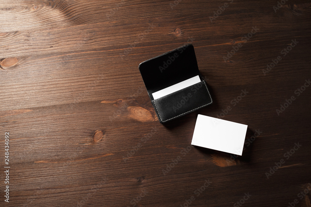 Blank business cards and leather business card holder on wooden background. Space for text. Blank business cards and leather business card holder on wooden background. Space for text.