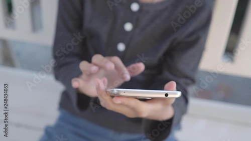 4k young Asian Thai boy play a smart phone in the garden.
