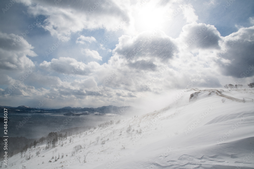 冬の地吹雪の美幌峠と屈斜路湖（北海道・弟子屈町）