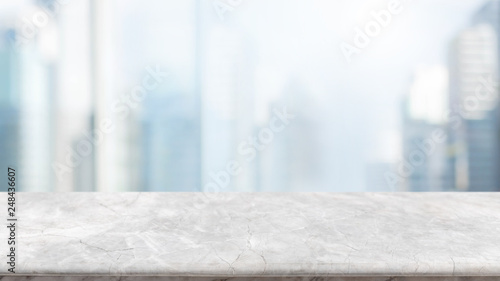 Empty white stone marble table top and blurred abstract background from interior building in city banner background - can used for display or montage your products.