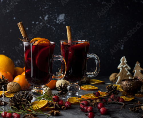 milled Hot wine with Christmas decorations background. Holiday dark photo.