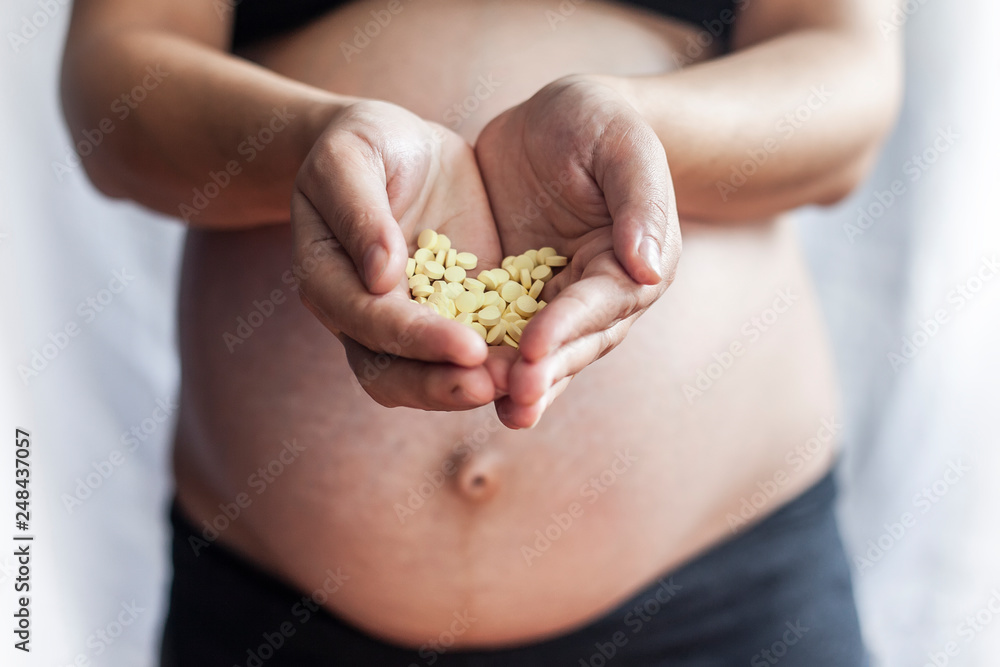 pregnant woman holding pills or drugs pregnant woman holding pills or drugs