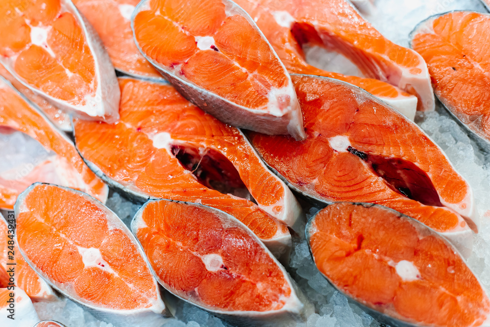 Trout or salmon sliced into pieces for steak lies in a frozen fridge of a display case in a supermarket Trout or salmon sliced into pieces for steak lies in a frozen fridge of a display case in a supermarket
