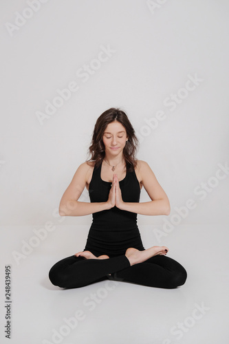 A fit young woman doing the lotus pose in yoga class. Relaxation and Stretching. Healthy lifestyle. Woman do yoga in fitness studio. © evelinphoto