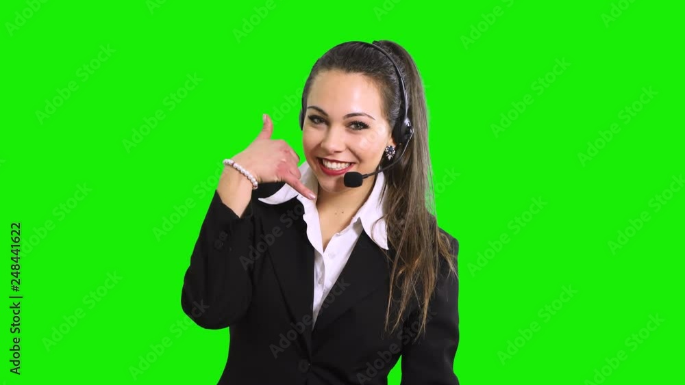 Beautiful consultant of call center in headphones on green screen chroma key background Beautiful consultant of call center in headphones on green screen chroma key background