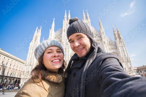 Travel, Italy and vacations concept - Happy tourists taking a self portrait in front of Duomo cathedral, Milan