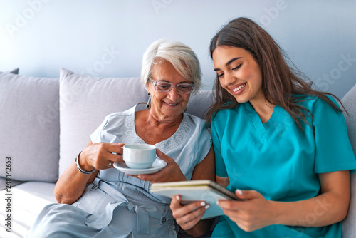 Young nurse spending time with happy elder patient in nursing home.