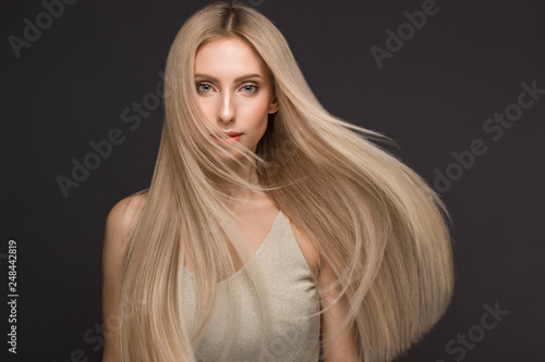 Billede på lærred Beautiful blond girl in move with a perfectly smooth hair, and classic make-up