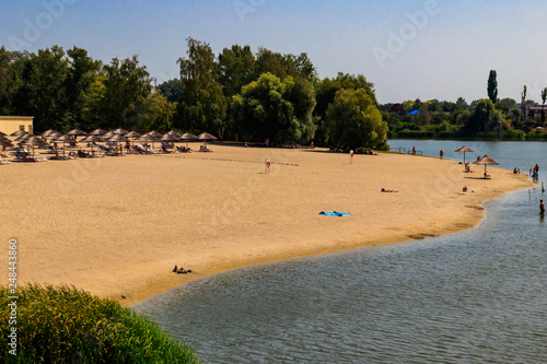 Tourists enjoy the sunny weather and relaxing on the sandy beach photo