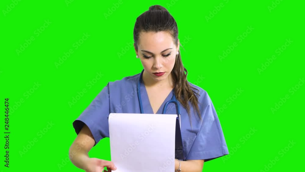 Female nurse reading documents on a clipboard isolated on green screen chroma key Female nurse reading documents on a clipboard isolated on green screen chroma key