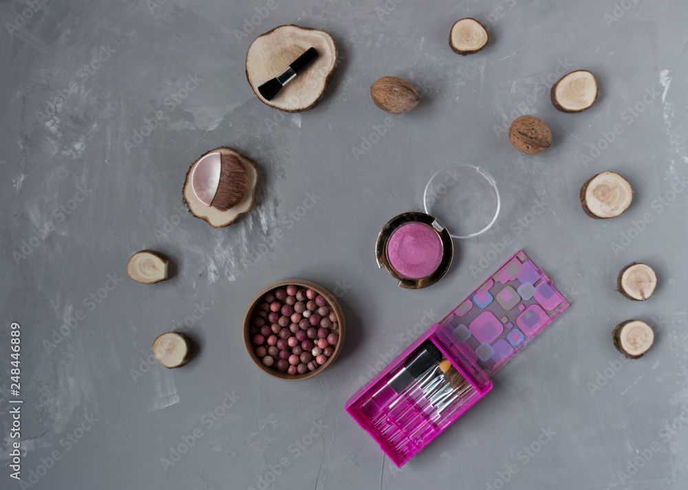A set of pink makeup brushes with blush on a gray phon A set of pink makeup brushes with blush on a gray phon